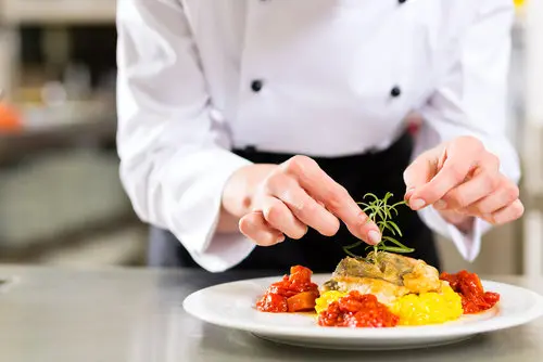 chef hands plating food in restaurant