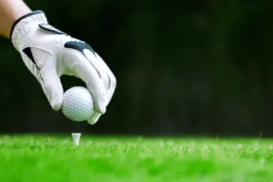 hand placing golf ball on a tee
