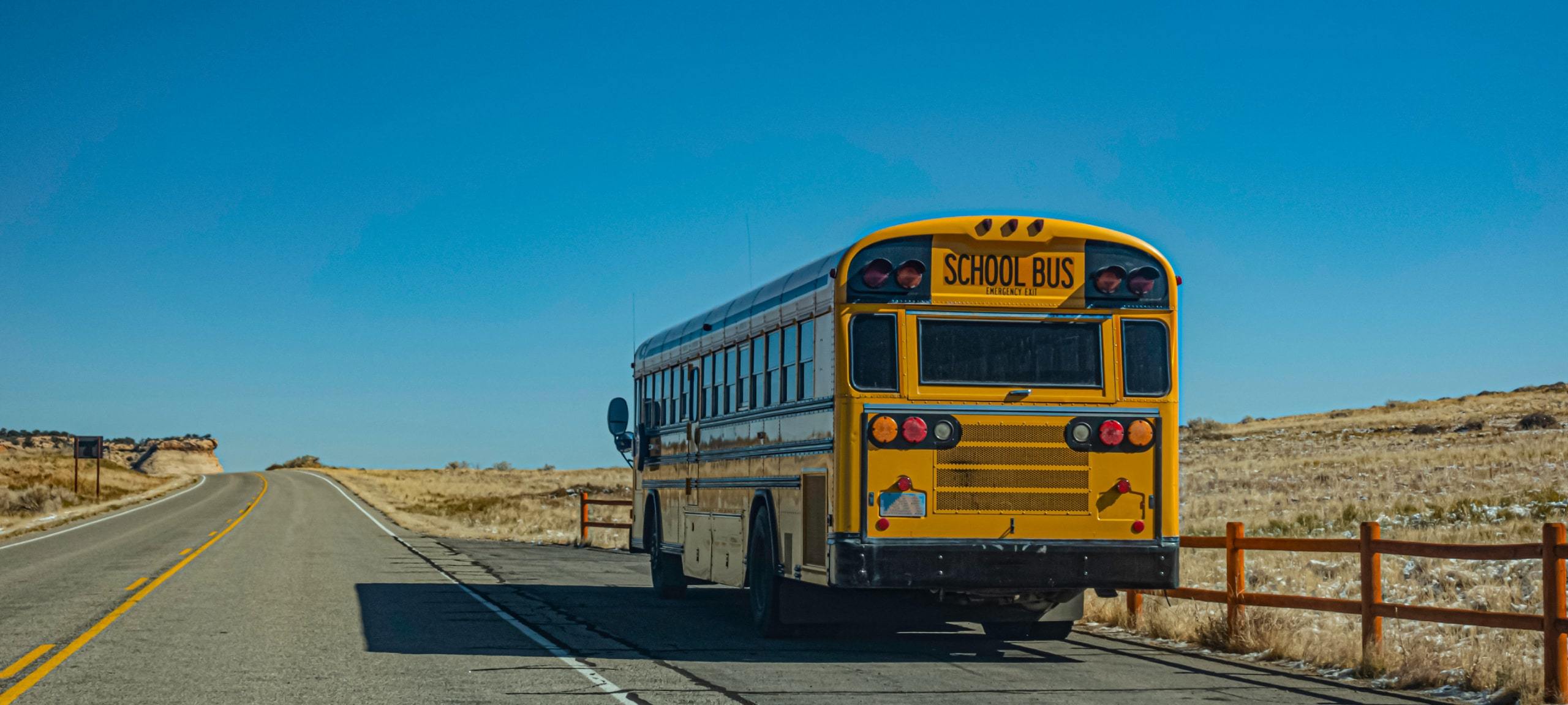 School bus on Utah road with blue sky