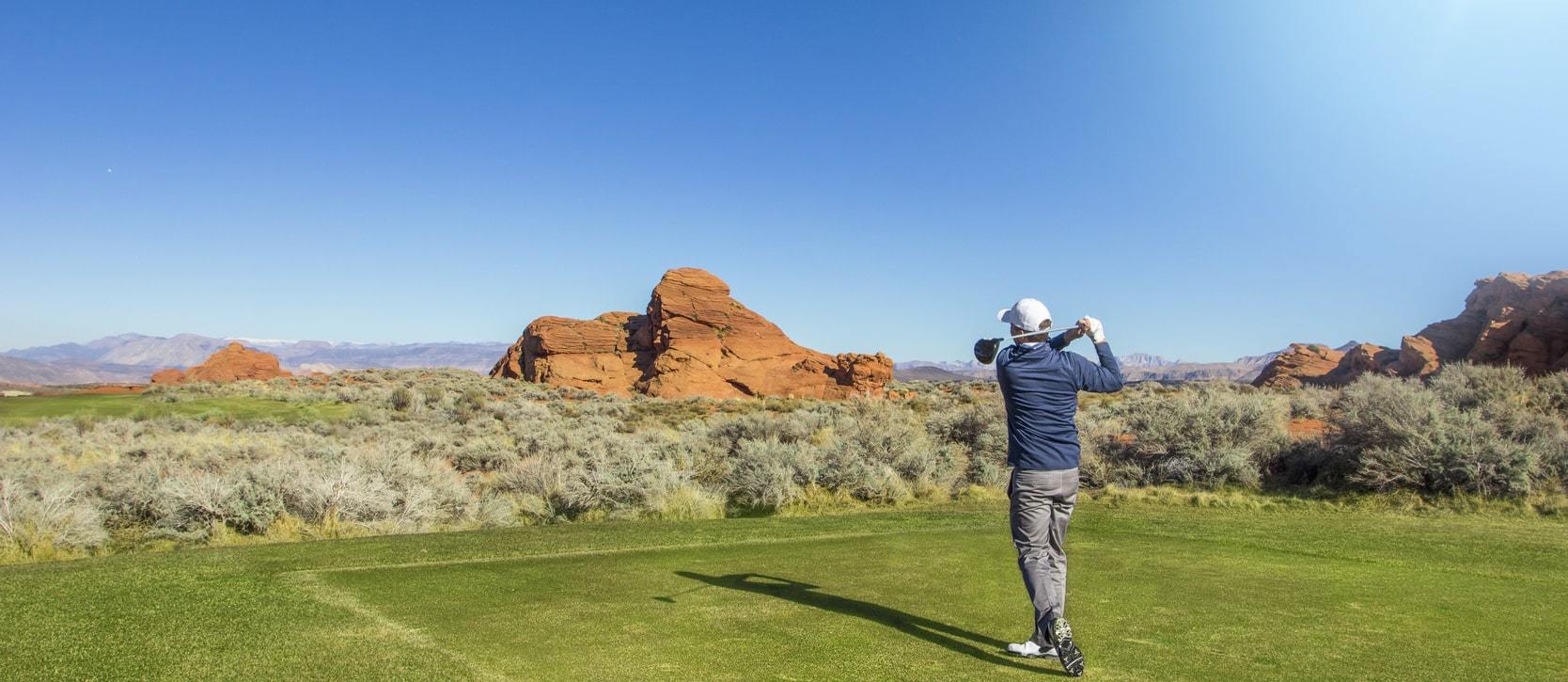 Person golfing with the Utah horizon in the back